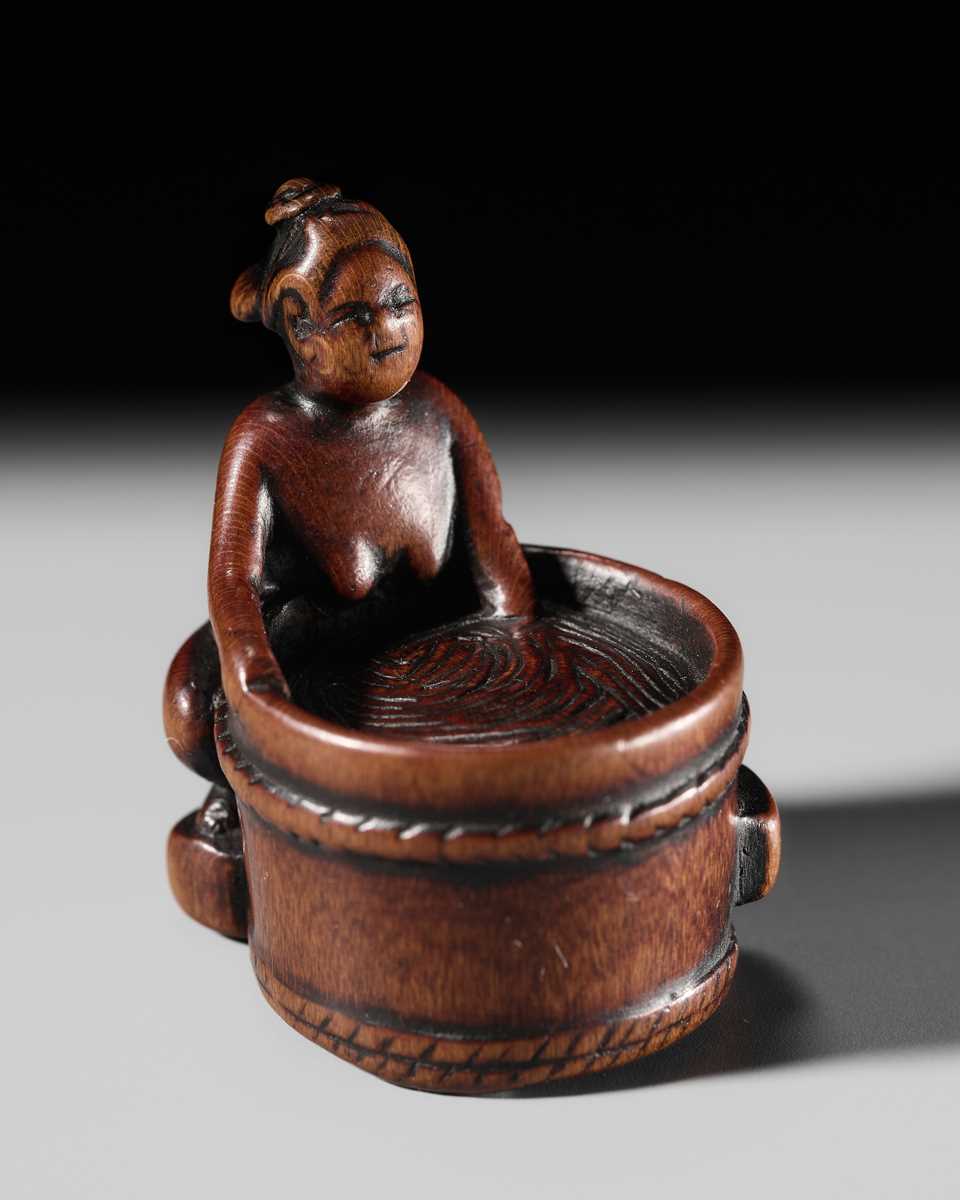 Lot 293 - A FINE SHUNGA WOOD NETSUKE OF A WOMAN TAKING