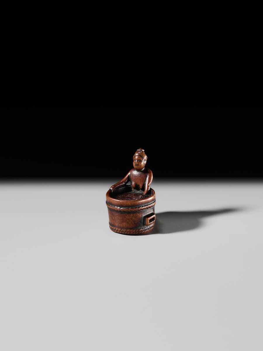 Lot 293 - A FINE SHUNGA WOOD NETSUKE OF A WOMAN TAKING