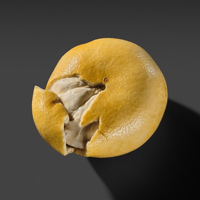 A FINE STAINED IVORY ‘TROMPE-L’OEIL’ OKIMONO OF A TANGERINE (MIKAN)
