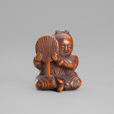 A WOOD NETSUKE OF A KARAKO HOLDING A FAN