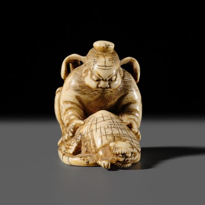 Lot 311 - A FINE ANTLER NETSUKE OF SHOKI TRAPPING AN ONI