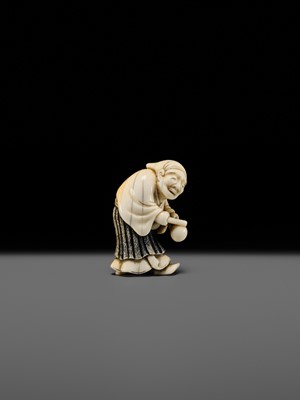 Lot 134 - MAZAKAZU: AN IVORY NETSUKE OF A HACHI-TATAKI PERFORMER