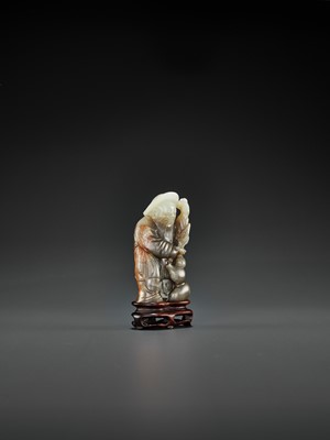Lot 66 - A PALE CELADON, GRAY AND RUSSET JADE FIGURE OF DONGFANG SHUO, QING DYNASTY