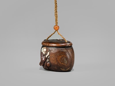 Lot 394 - TANAKA MINKO: AN INLAID WOOD TONKOTSU WITH A RAOYA CLEANING A SMOKING PIPE (KISERU)