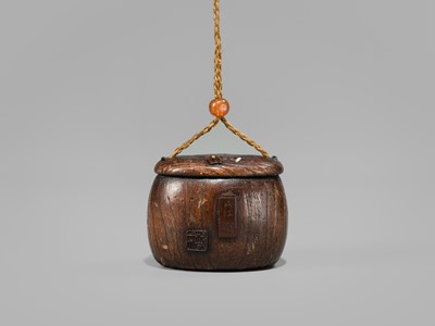 Lot 394 - TANAKA MINKO: AN INLAID WOOD TONKOTSU WITH A RAOYA CLEANING A SMOKING PIPE (KISERU)