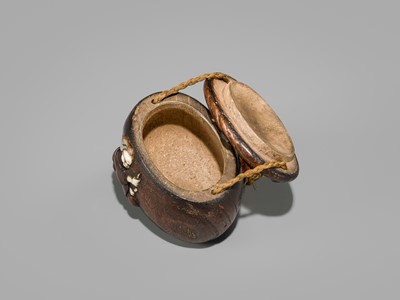 Lot 394 - TANAKA MINKO: AN INLAID WOOD TONKOTSU WITH A RAOYA CLEANING A SMOKING PIPE (KISERU)