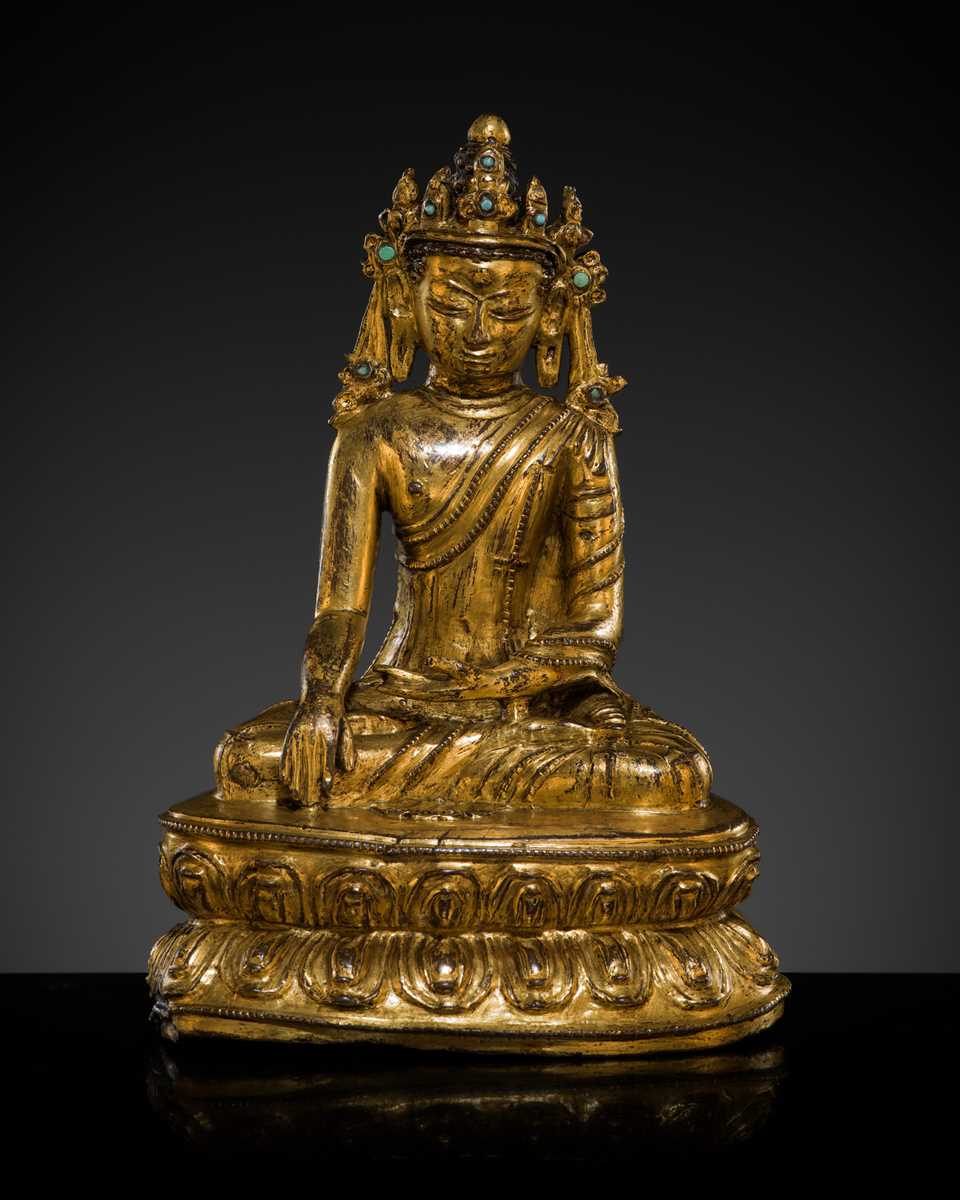 A TURQUOISE-INLAID GILT COPPER-ALLOY FIGURE OF THE CROWNED BUDDHA, TIBET, CIRCA 15TH-16TH CENTURY