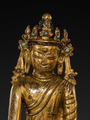 A TURQUOISE-INLAID GILT COPPER-ALLOY FIGURE OF THE CROWNED BUDDHA, TIBET, CIRCA 15TH-16TH CENTURY