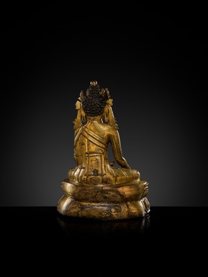 A TURQUOISE-INLAID GILT COPPER-ALLOY FIGURE OF THE CROWNED BUDDHA, TIBET, CIRCA 15TH-16TH CENTURY