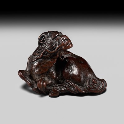 Lot 188 - ITTAN: A SUPERB NAGOYA SCHOOL WOOD NETSUKE OF A RECUMBENT KIRIN