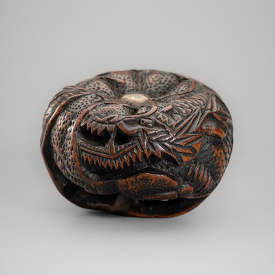 A WOOD NETSUKE OF A DRAGON AMONG FOLIAGE