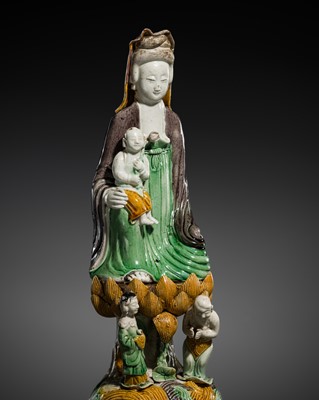 Lot 238 - A FINE SANCAI-GLAZED BISCUIT PORCELAIN GROUP OF SONGZI GUANYIN, KANGXI PERIOD