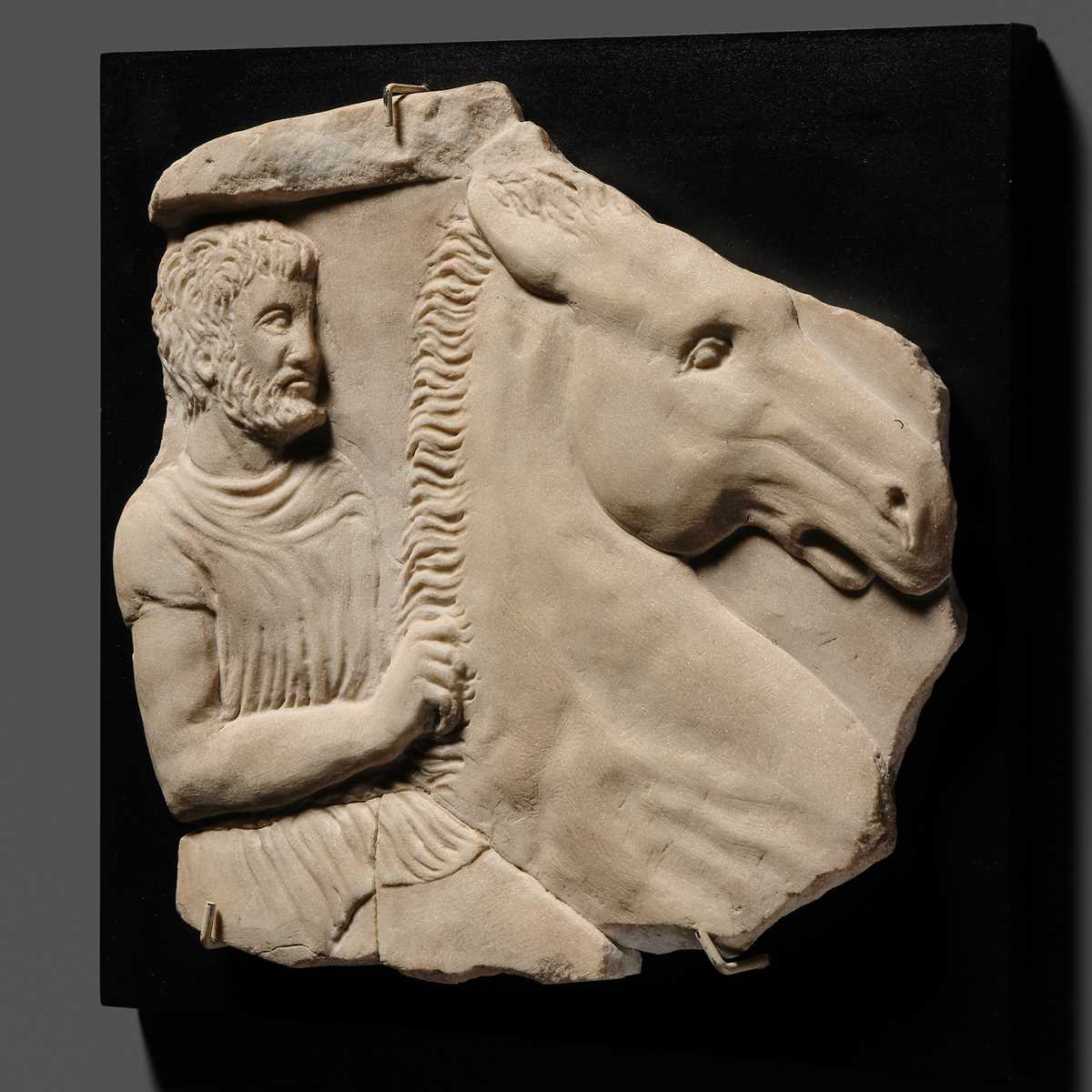Lot 65 - A ROMAN WHITE MARBLE RELIEF FRAGMENT OF A SARCOPHAGUS DEPICTING A HORSEMAN AND STEED, CIRCA 2ND CENTURY AD