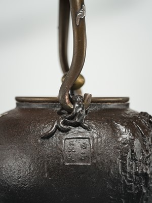 Lot 43 - RYUBUNDO: AN IRON TEA KETTLE (TETSUBIN) WITH A NOCTURNAL LANDSCAPE UNDER THE CRESCENT MOON