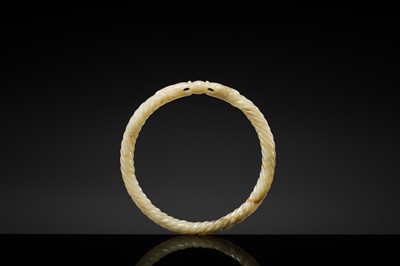 A DELICATE CELADON AND BROWN ’DRAGON’ JADE ROPE-TWIST BANGLE, QING DYNASTY