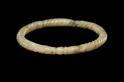 A DELICATE CELADON AND BROWN ’DRAGON’ JADE ROPE-TWIST BANGLE, QING DYNASTY