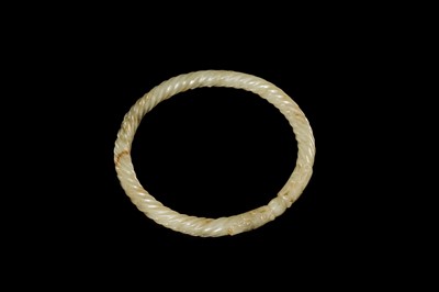 A DELICATE CELADON AND BROWN ’DRAGON’ JADE ROPE-TWIST BANGLE, QING DYNASTY