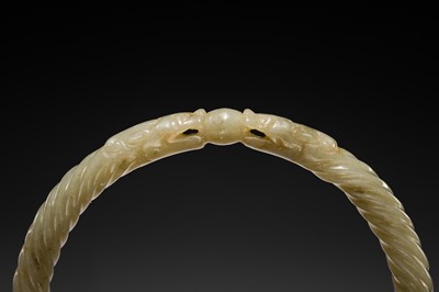 A DELICATE CELADON AND BROWN ’DRAGON’ JADE ROPE-TWIST BANGLE, QING DYNASTY