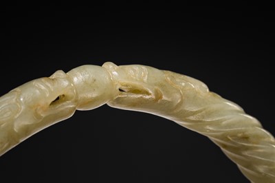 A DELICATE CELADON AND BROWN ’DRAGON’ JADE ROPE-TWIST BANGLE, QING DYNASTY