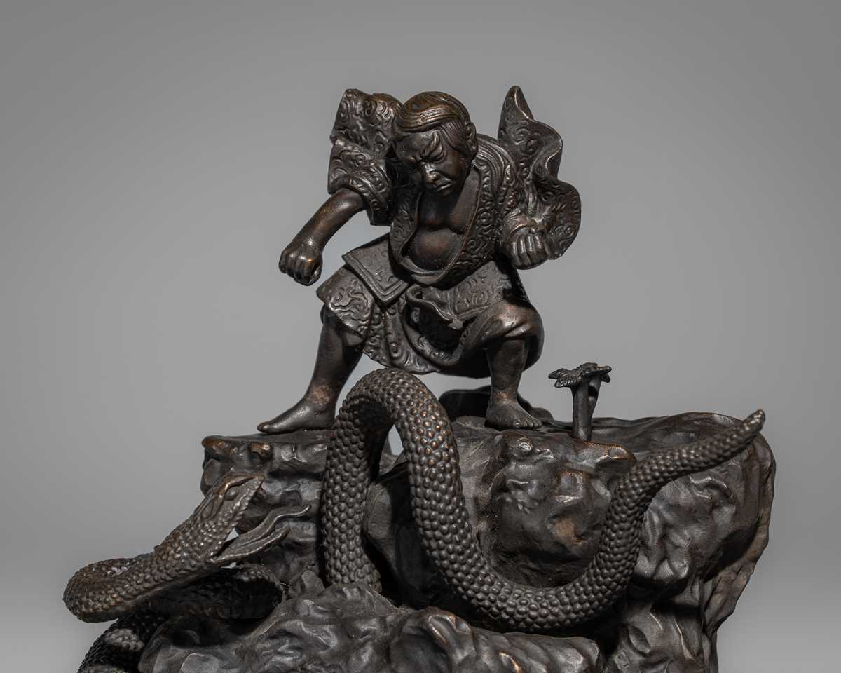 A BRONZE FIGURE OF A SNAKE SLAYING WARRIOR