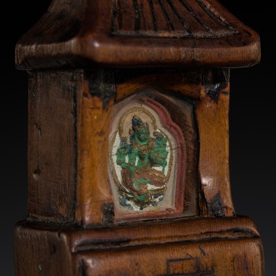 Lot 132 - A PORTABLE WOOD SHRINE WITH A PAINTED CLAY TSA-TSA OF GREEN TARA, GAU, 18TH-19TH CENTURY