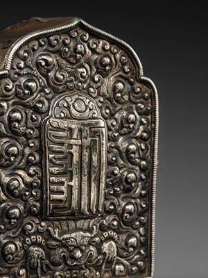 Lot 134 - AN EMBOSSED SILVER AND COPPER PORTABLE SHRINE WITH THE KALACHAKRA MONOGRAM, GAU, 19TH CENTURY
