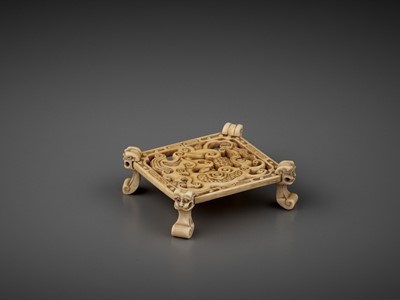 Lot 575 - A CARVED OPENWORK IVORY ‘MYTHICAL BEAST’ STAND, QING DYNASTY