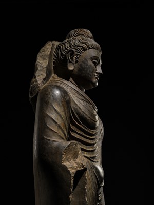 Lot 16 - A LARGE AND IMPORTANT POLISHED GRAY SCHIST FIGURE OF BUDDHA SHAKYAMUNI, ANCIENT REGION OF GANDHARA, SWAT VALLEY, 2ND-4TH CENTURY