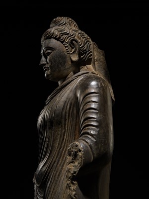 Lot 16 - A LARGE AND IMPORTANT POLISHED GRAY SCHIST FIGURE OF BUDDHA SHAKYAMUNI, ANCIENT REGION OF GANDHARA, SWAT VALLEY, 2ND-4TH CENTURY