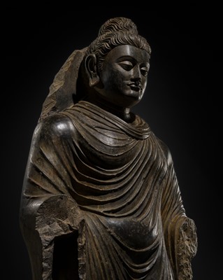 Lot 16 - A LARGE AND IMPORTANT POLISHED GRAY SCHIST FIGURE OF BUDDHA SHAKYAMUNI, ANCIENT REGION OF GANDHARA, SWAT VALLEY, 2ND-4TH CENTURY