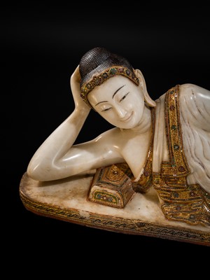 Lot 15 - A LARGE GLASS INLAID AND GILDED ALABASTER FIGURE OF THE RECLINING BUDDHA, MANDALAY PERIOD, 19TH CENTURY