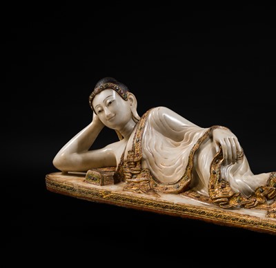 Lot 15 - A LARGE GLASS INLAID AND GILDED ALABASTER FIGURE OF THE RECLINING BUDDHA, MANDALAY PERIOD, 19TH CENTURY