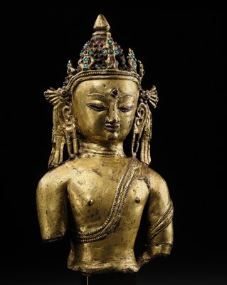 Lot 48 - A RARE GILT-BRONZE BUST OF BUDDHA SHAKYAMUNI, EARLY MALLA PERIOD, NEPAL, 14TH-15TH CENTURY