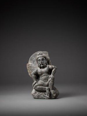 Lot 543 - A GRAY SCHIST FIGURE OF A WINGED ATLAS, GANDHARA