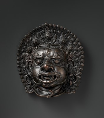 Lot 447 - A MASSIVE AND FIERCE BRONZE MASK OF BHAIRAVA, 18TH CENTURY OR EARLIER