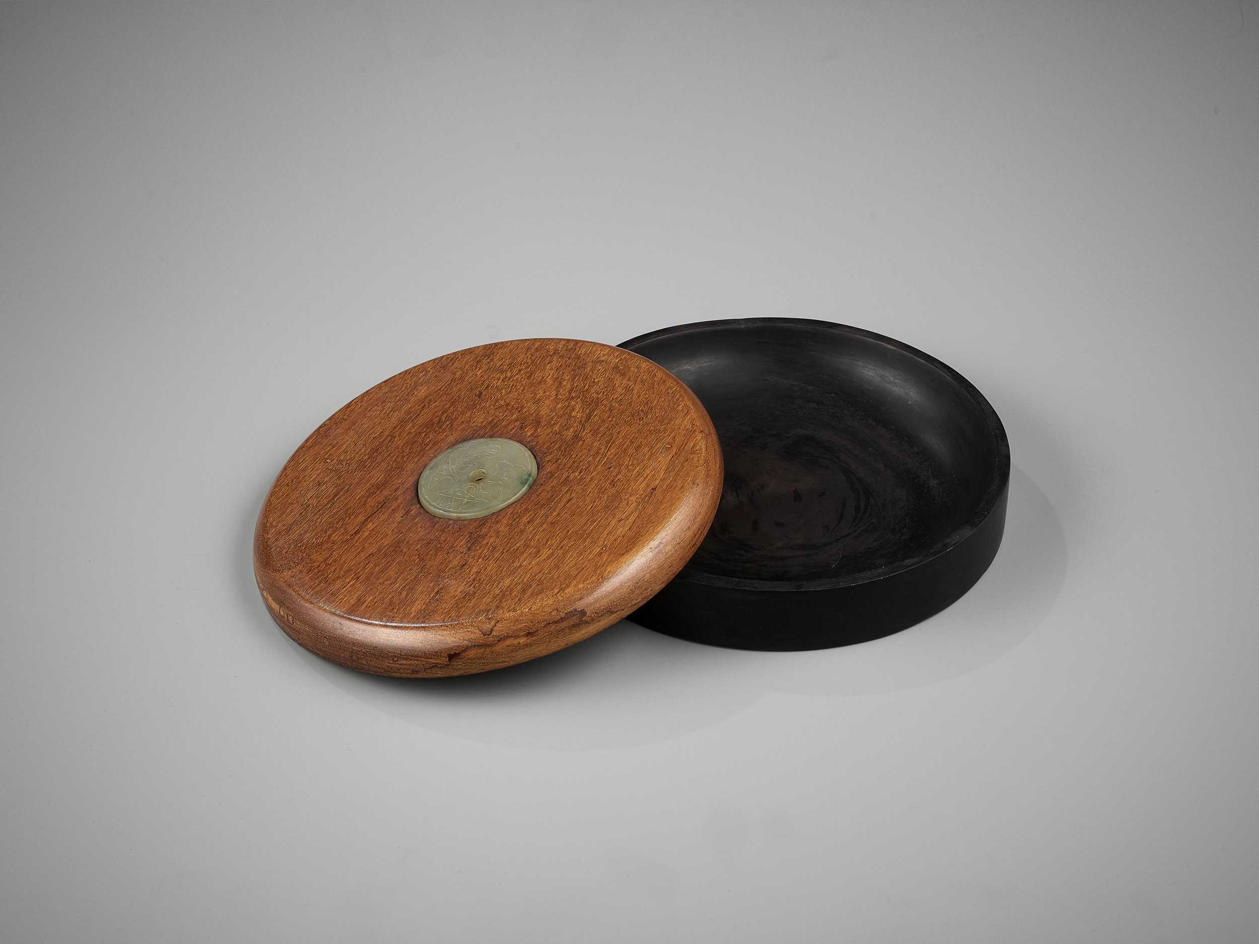 Lot 32 - A DUAN INKSTONE WITH A JADEITE-INSET HUANGHUALI COVER, QING