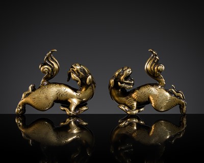 Lot 211 - A PAIR OF SMALL GILT-BRONZE ‘GUARDIAN LION’ WEIGHTS, MING TO EARLY QING DYNASTY