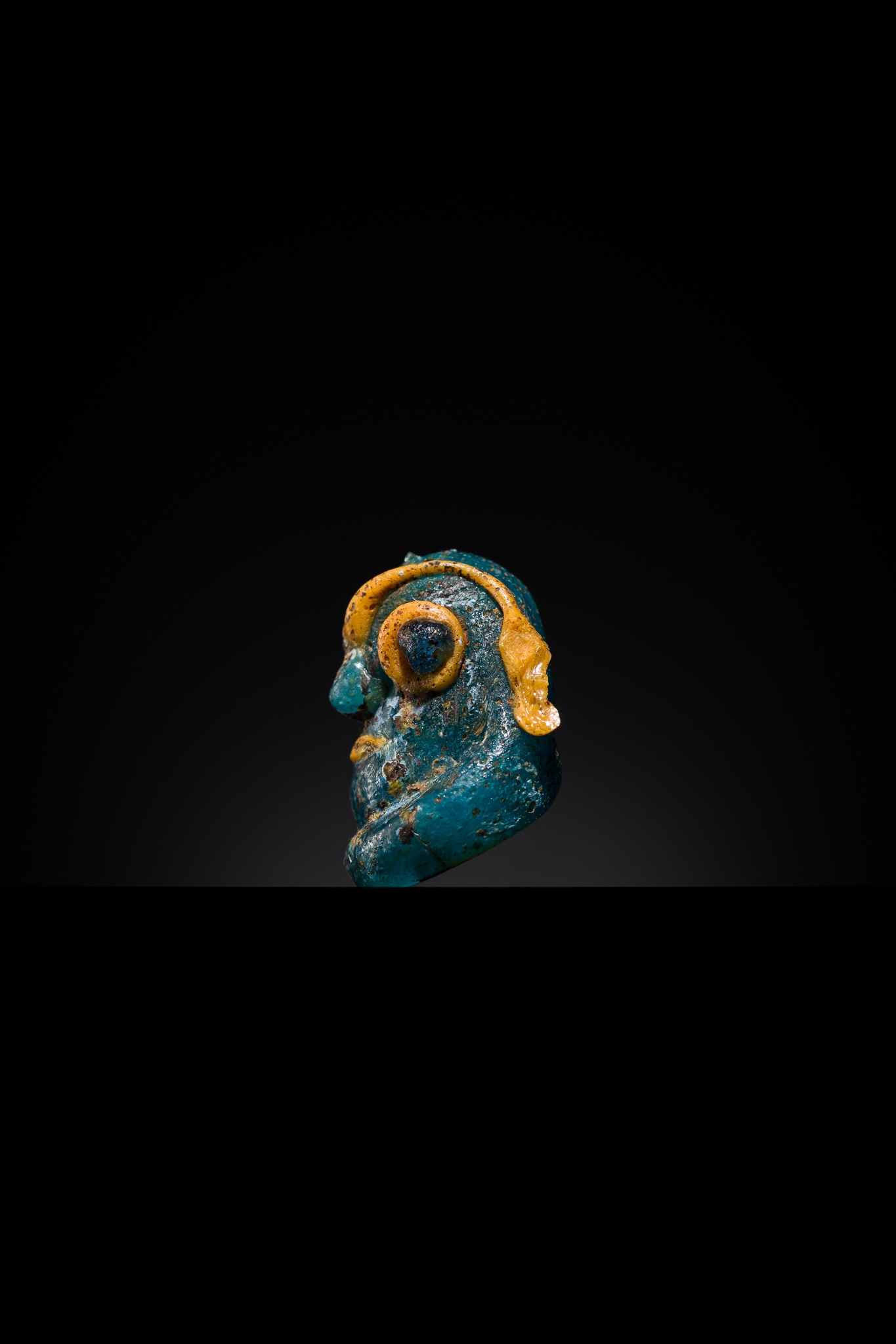 Lot 66 - A CARTHAGINIAN ‘DEMONIC MASK’ GLASS PENDANT,
