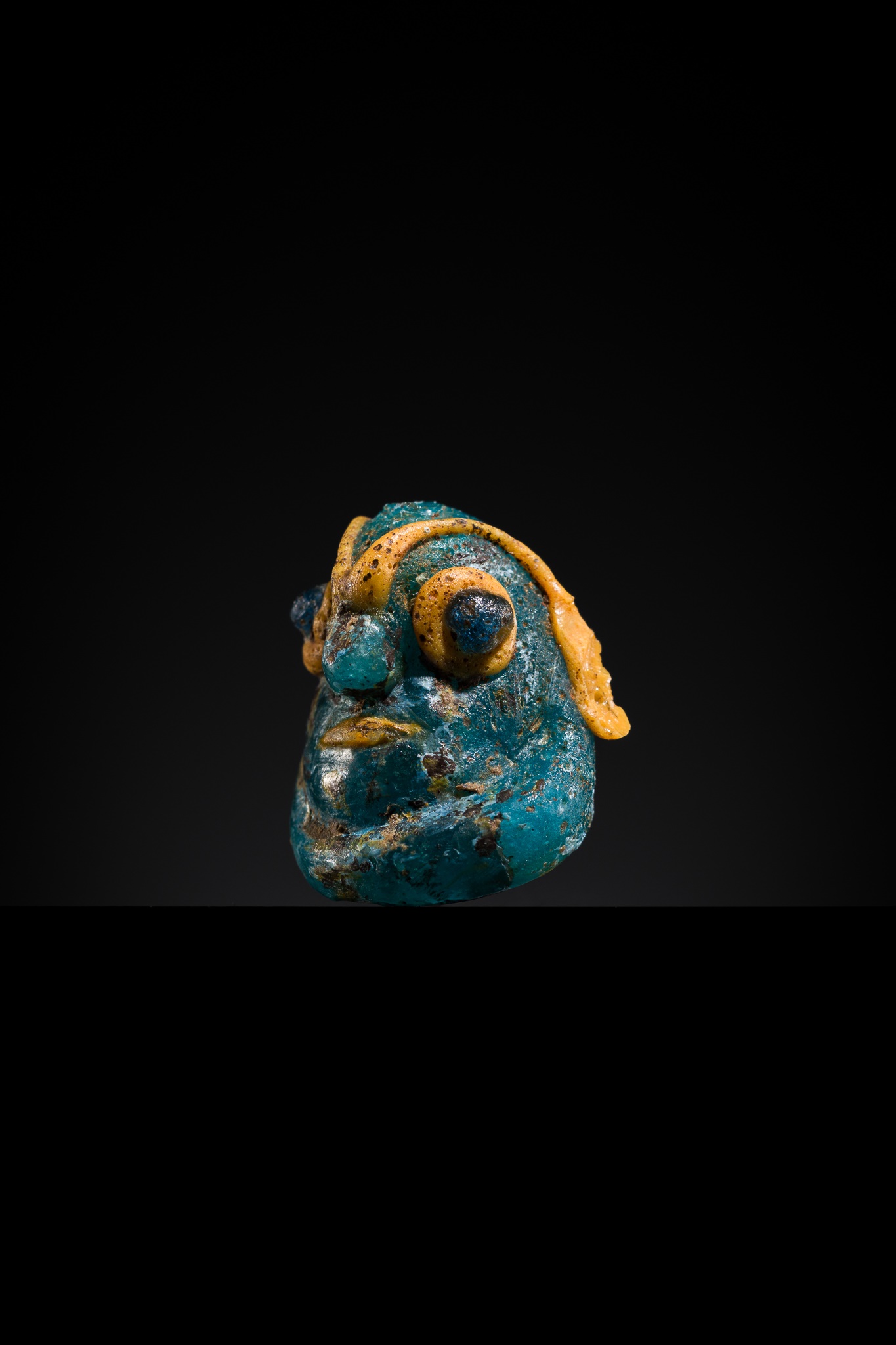 Lot 66 - A CARTHAGINIAN ‘DEMONIC MASK’ GLASS PENDANT,