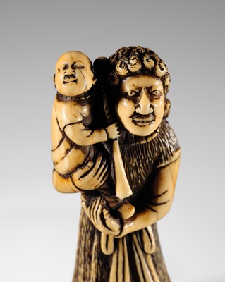 A TALL IVORY NETSUKE OF A DUTCHMAN WITH A TRUMPET AND CHILD