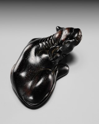 A LARGE AND IMPRESSIVE KUROGAKI (BLACK PERSIMMON) WOOD NETSUKE OF A RECUMBENT OX