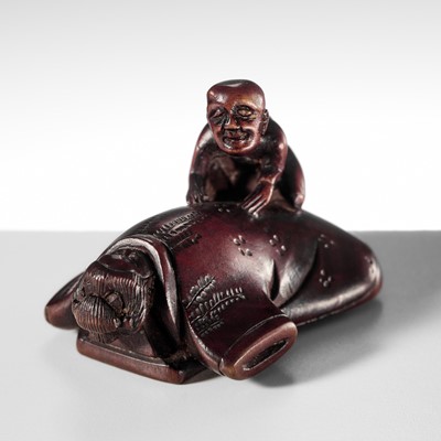 GENRAKU: A RARE AND UNUSUAL WOOD NETSUKE OF A LADY AND BLIND MASSEUR