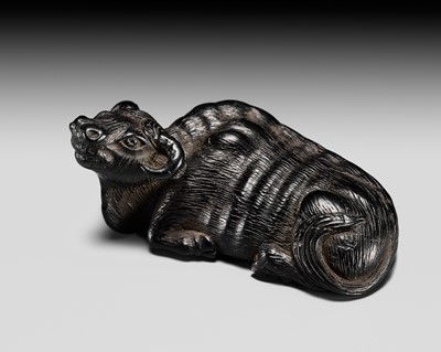 RYUSUI: A RARE IWAMI SCHOOL EBONY WOOD NETSUKE OF A RECUMBENT OX