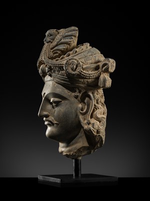 Lot 248 - A LARGE SCHIST HEAD OF A BODHISATTVA WITH A ‘KĪRTIMUKHA’ TURBAN, GANDHARA, 4TH–5TH CENTURY, FORMERLY IN THE COLLECTION OF BEGUM BAKHT ZEBA