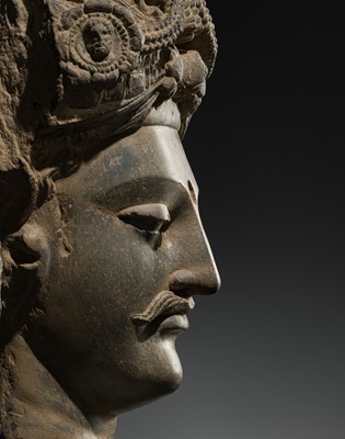 Lot 248 - A LARGE SCHIST HEAD OF A BODHISATTVA WITH A ‘KĪRTIMUKHA’ TURBAN, GANDHARA, 4TH–5TH CENTURY, FORMERLY IN THE COLLECTION OF BEGUM BAKHT ZEBA