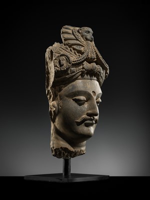 Lot 248 - A LARGE SCHIST HEAD OF A BODHISATTVA WITH A ‘KĪRTIMUKHA’ TURBAN, GANDHARA, 4TH–5TH CENTURY, FORMERLY IN THE COLLECTION OF BEGUM BAKHT ZEBA
