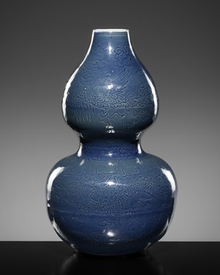Lot 257 - AN INCISED BLUE-GLAZED ‘DRAGON AND PHOENIX’ DOUBLE GOURD VASE, LATE MING DYNASTY