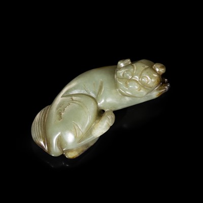 Lot 218 - A CELADON JADE FIGURE OF A RECUMBENT DOG, 17TH-18TH CENTURY