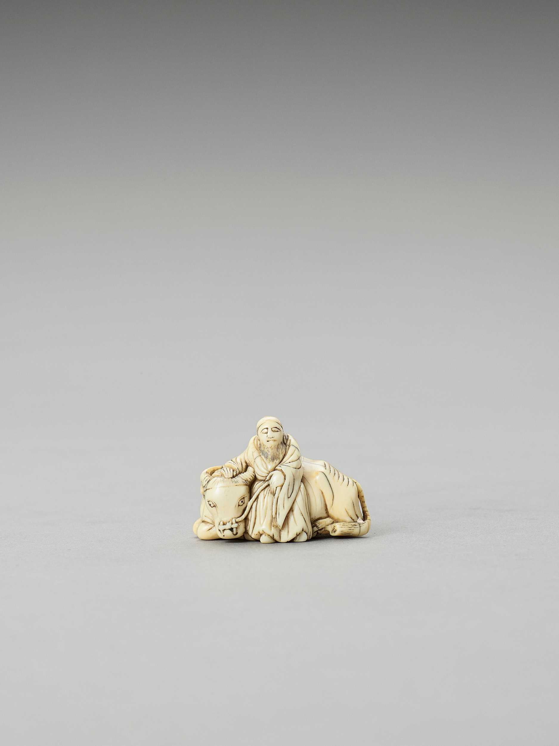 Lot 343 - AN EARLY IVORY NETSUKE OF ROSHI WITH OX