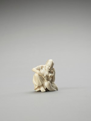 Lot 241 - AN IVORY OKIMONO OF A RAKAN CLEANING HIS EAR